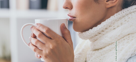 Frau mit einem grippalen Infekt trinkt einen Tee.