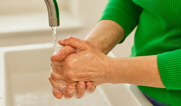 Mann wäscht sich gründlich die Hände unter einem Wasserhahn